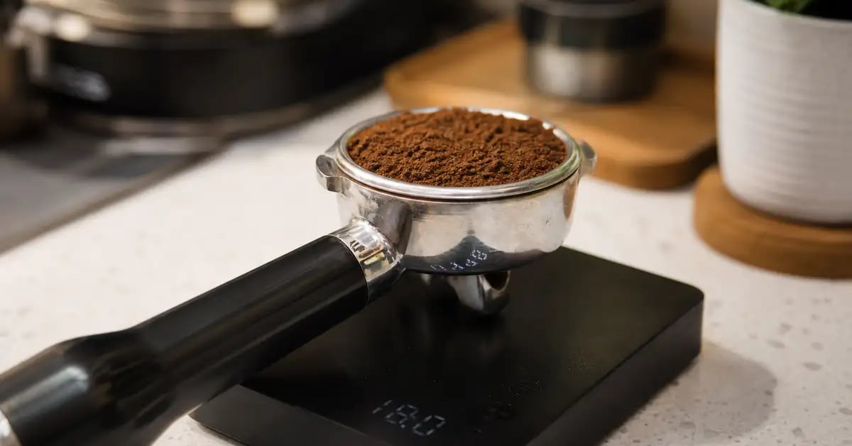 Portafilter on a digital coffee scale with fine ground coffee in the basket