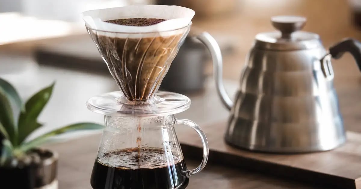 V60 pour-over dripper on a server with a gooseneck kettle in soft morning light