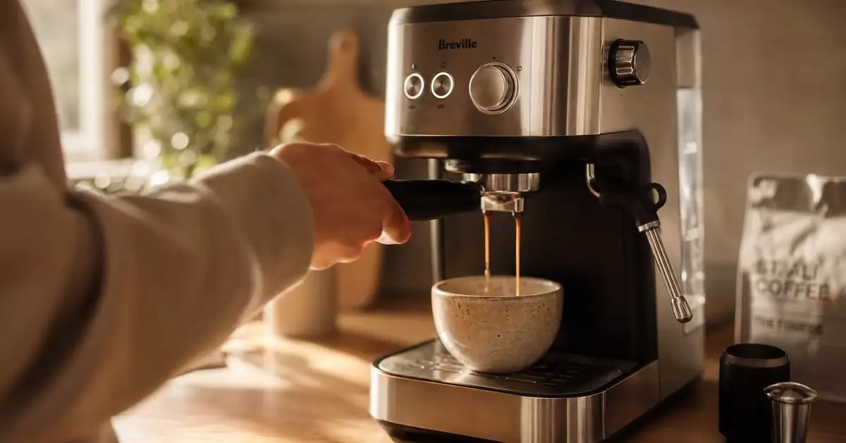 Barista pulling espresso on a home machine with warm morning light